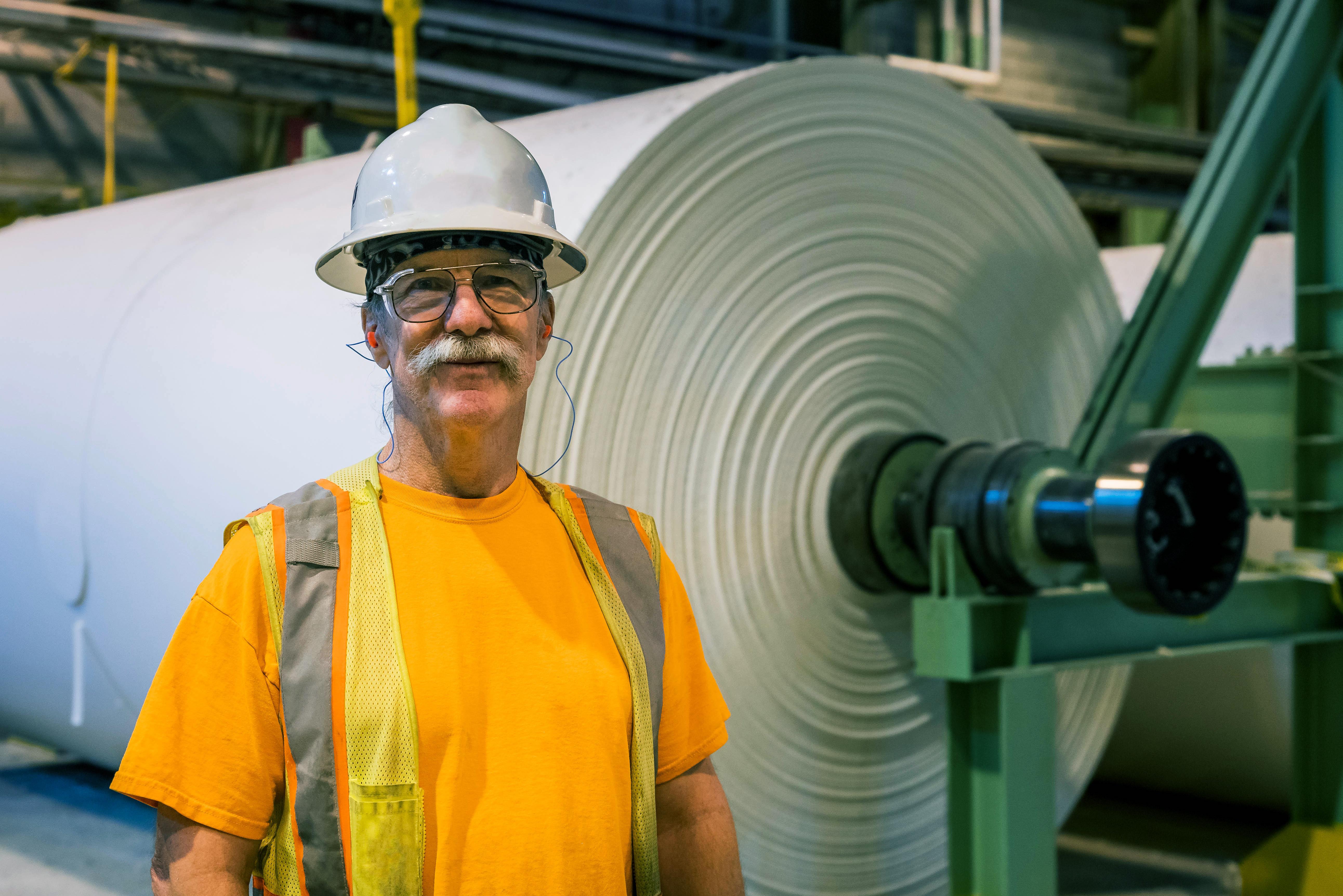 man standing in front of white paper roll